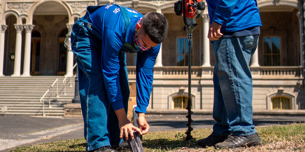 Pest control solutions product catalog. An image of pest management professionals installing termite detection tool. 